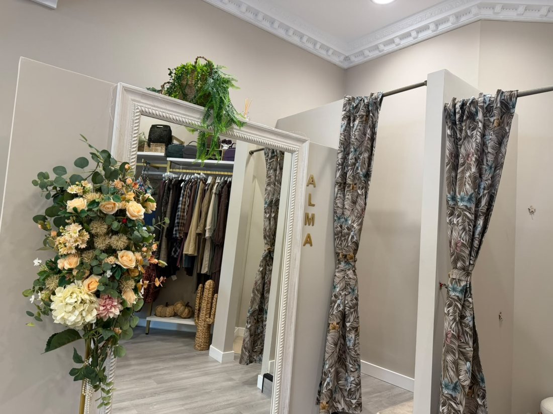 Probadores con cortinas estampadas, espejo blanco y ramo de flores